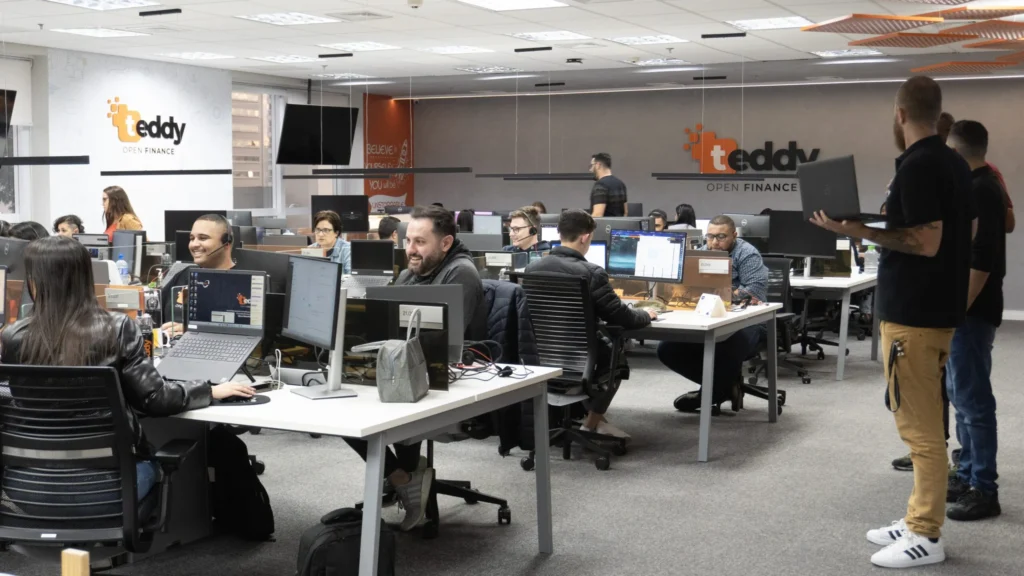 ambiente de tranalho da Teddy Open Finance, com a mesa dos especialistas
